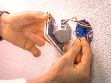 Caen, Fransa, Nisan 2022. Dokunma düğmesi - soket kurulumu, elektrik kabloları bağlantısı