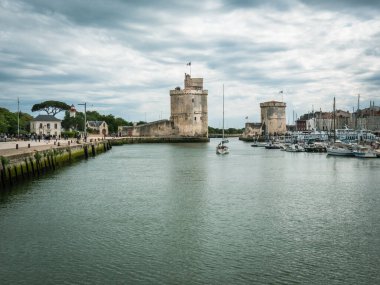 La Rochelle, Fransa, Temmuz 2022. La Rochelle 'in eski limandaki iki kule manzarası, güzel mimari, limanda duran yelkenli teknelerin yanındaki mavi gökyüzü, serbest alan.