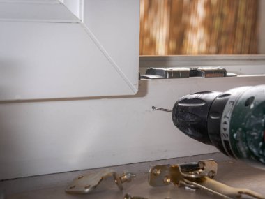 installation of a window stop, drilling holes for screws in plastic window frames