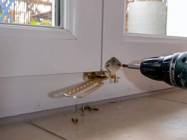 installation of a window stop, drilling holes for screws in plastic window frames