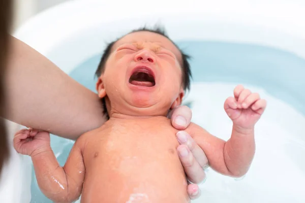 องไห ทารกแรกเก ดเอเช ยอาบน าในอ างอาบน าแม อาบน กชายของเธอในน นของทารกแรกเก — ภาพถ่ายสต็อก