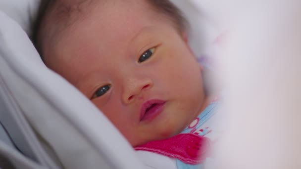 赤ちゃんのベッドに横たわっ幸せな新生児 カメラで笑顔 罪のない目の快適さとリラックスした愛らしいアジアの新生児 新生児の写真のコンセプト — ストック動画