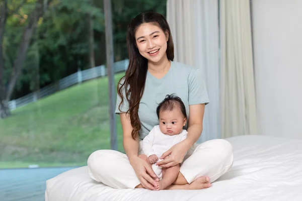 สาวเอเช สวยงาม บเด กทารกแรกเก ดไว ในอ อมแขน งบนเต ยงท านท — ภาพถ่ายสต็อก