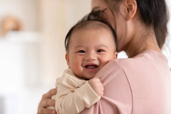 快適な新生児の笑顔と母親の腕の安全性と快適さでリラックスします ロイヤリティフリーのストック写真