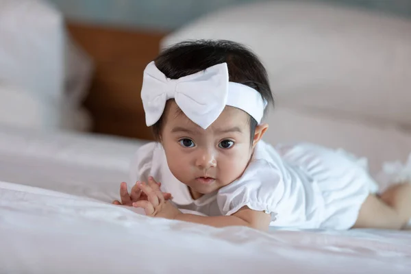 Beyaz Yatakta Uzanıp Kameraya Rahatça Bakan Sevimli Bir Kız Bebek — Stok fotoğraf