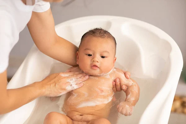 ใจเย นของทารกแรกเก ดเอเช ยอาบน าในอ างอาบน อาบน กชายของเธอในน ความส ขทารกแรกเก รูปภาพสต็อกที่ปลอดค่าลิขสิทธิ์