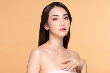 Kendine güvenen genç bir kadın yumuşak ve kusursuz cildini gösteriyor. Mankenlik onu güzel ve çekici yapıyor. Uzun siyah saçları var. Askısız elbise bize onun açık derisini gösterebilir..