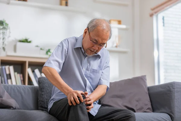 Orang Tua Asia Dengan Lutut Nyeri Sendi Sofa Rasa Sakit — Stok Foto