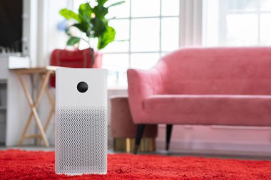 Evdeki tozu, PM2.5 HEPA 'yı ve virüsü, temiz hava ve sağlıklı yaşam için, hava kirliliği kavramını temizlemek ve filtrelemek için rahat beyaz oturma odasında hava temizleyicisi.