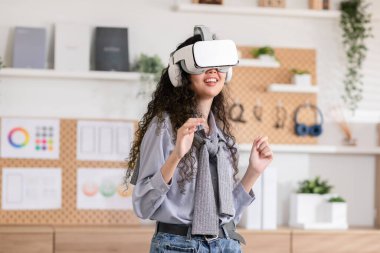 Meta-evren dünyasında sanal gerçeklik gözlüğü kullanan Asyalı bir kadın. VR kullanan genç kadın gözlüğü evde dans etmekten zevk alıyor. 360 derece oynuyorlar. Sanal gerçeklik boyutu.