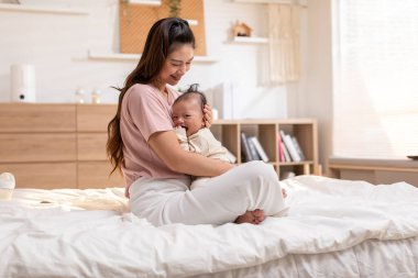 Sevimli yeni doğmuş bebek gülümse ve anne kollarında rahatla. Sağlıklı Asyalı yeni doğmuş bebek mutlulukla gülüyor. Anne kucağında bebek bebeği kavramı.