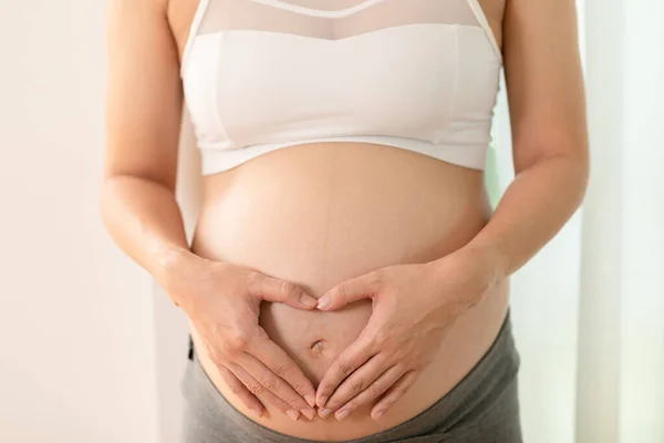 Sztandar Blisko Palca Kobiety Ciąży Trzyma Brzuchu Kształtowanie Serca Dla — Zdjęcie stockowe