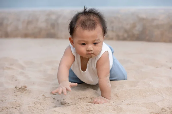 健康的亚洲幼儿在海滩上爬行 学习在户外爬行 可爱的婴儿把她的腹部和腿放在沙滩上 让它在家里爬来爬去 开心而快乐 婴儿成长概念 — 图库照片