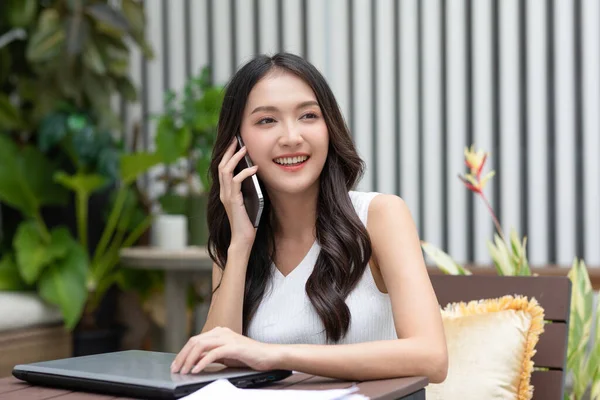 アジアの若い女性は 電話に答え 肯定的かつ幸福感と話をします スマートフォンの笑顔で魅力的な女性の話と家で良いニュースと良い瞬間で安心 — ストック写真