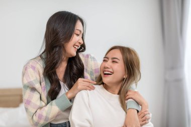 Güzel iki kadın LGBT lezbiyen kucaklaşıyorlar ve yatakta aşk ve romantizmle birlikte bakıyorlar. Pozitif ruh hali ve LGBTQ lezbiyen beyaz yatakta uzanıyor rahatla ve rahatla. LGBTQ Yaşam Tarzı