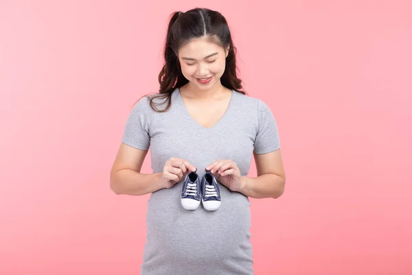 Asian Pregnant Woman Holding Baby Sneakers Baby Newborn Isolated Pink — Stockfoto