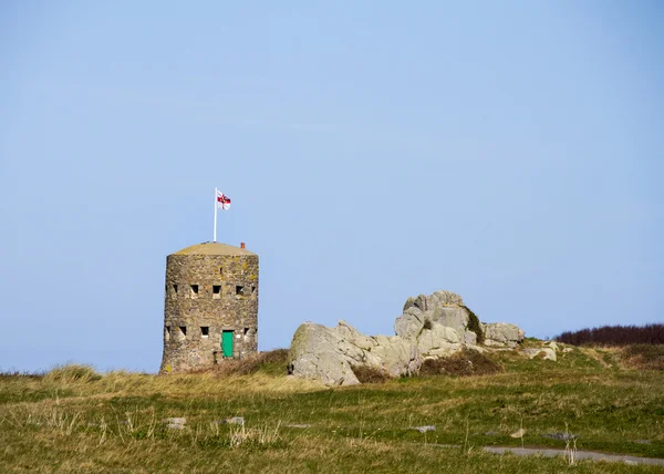 Maas in de wet torens in guernsey die de kustlijn bewaken. — Stockfoto