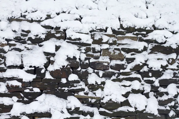 Snö på en torr stenmur — Stockfoto