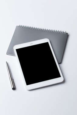 dokunmatik tablet, not defteri ve kalem beyaz zemin üzerine