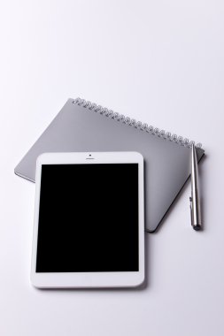 dokunmatik tablet, not defteri ve kalem beyaz zemin üzerine