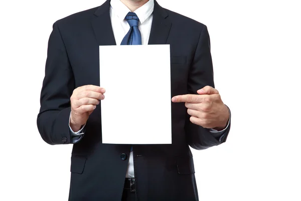 Businessman pointing at sign he is holding against a white background — Stock Photo, Image