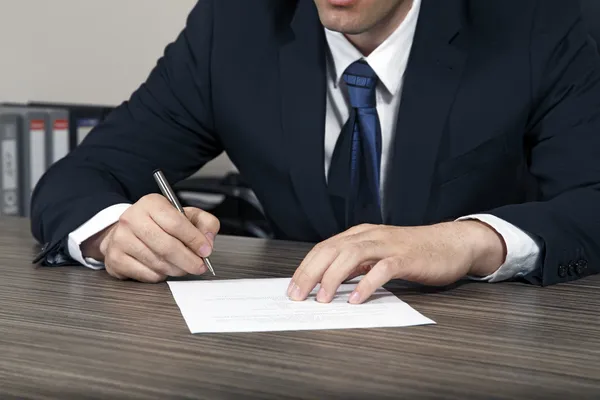 Businessman signs a document at your desk — Stock Photo, Image