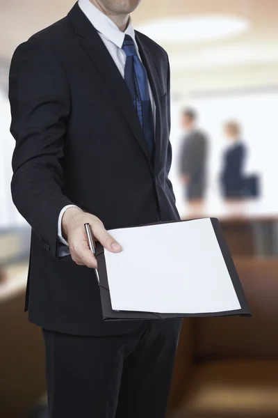 Бизнесмен о передаче документа о соглашении на офисном фоне Стоковая Картинка