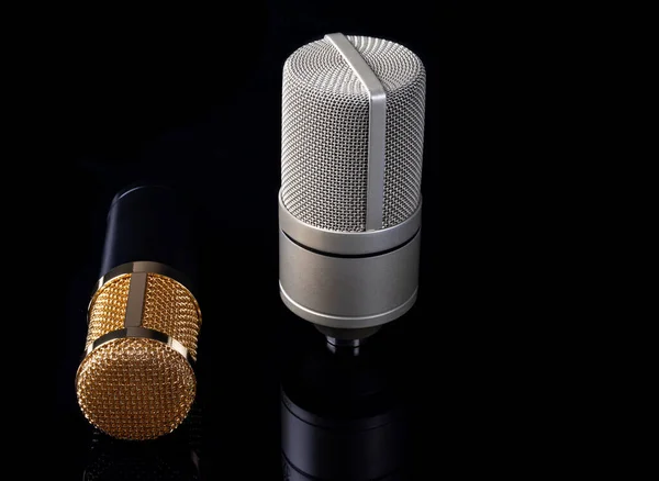 Siyah bir arkaplanda stüdyo kaydı için bir çift yoğunlaştırıcı mikrofon