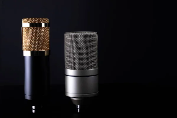Siyah bir arkaplanda stüdyo kaydı için bir çift yoğunlaştırıcı mikrofon