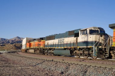 Cajon Pass, California, USA - February 26, 2021: image of a BNSF Railway train including engine 9745 in the Executive paint scheme shown traveling through the Cajon Pas in San Bernardino County.