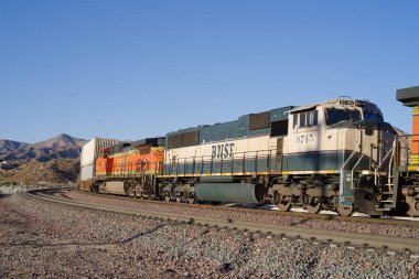 Cajon Pass, California, USA - February 26, 2021: image of a BNSF Railway train including engine 9745 in the Executive paint scheme shown traveling through the Cajon Pas in San Bernardino County. clipart