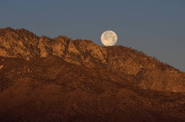 Kaliforniya 'da Palm Springs yakınlarında bir dağ sırasının üzerinde ay batıyor..