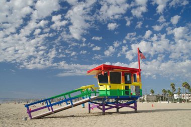 Hermosa Sahili, Kaliforniya, ABD - 22 Eylül 2022: Kırık bulutlu mavi gökyüzüne karşı LGBTQ topluluğunun onuruna gökkuşağı renklerine boyanmış cankurtaran kulesi.