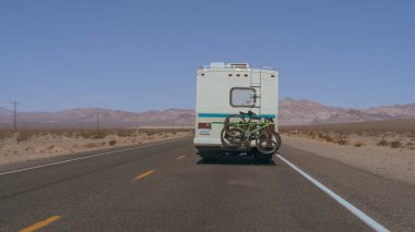 Nevada, ABD - 26 Şubat 2022: Güneşli bir günde ıssız bir çölde bisiklet parkında iki bisikletli bir karavanın görüntüsü.