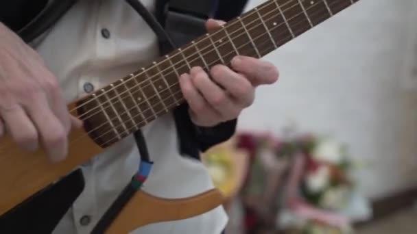 一个男人的手在特写中弹奏吉他 一个人的手指握住吉他的颈部 男人的手指弹吉他弹得很快 人的手在吉它的脖子上弹奏 柔和的焦点 — 图库视频影像