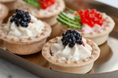 Altın tepside siyah ve kırmızı havyar tartları.