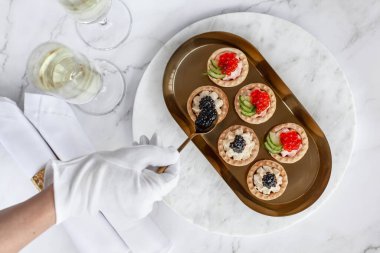 Garson altın tepside siyah ve kırmızı havyar turtası servis etti.