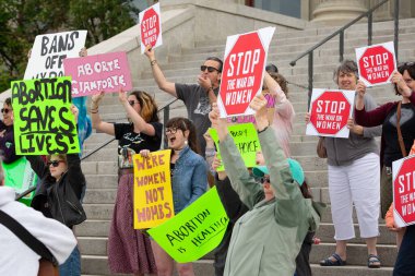 Helena, Montana - June 24, 2022: women protesting abortion ban and overturning of roe vs wade by Supreme Court at the state capitol, holding pro choice signs, abortions saves lives, women's march clipart