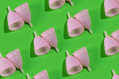 Parlak yeşil bir zemin üzerinde hassas silikondan yapılmış iki adet pembe bardağının kusursuz deseni..