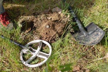 a metal cork from a bottle found with a wireless metal detector on a background of grass