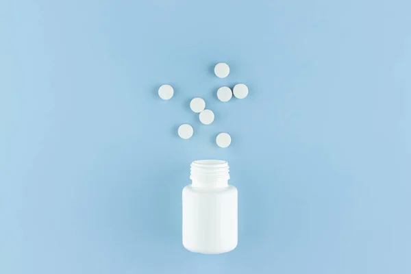 White Pills Scattered White Plastic Jar Blue Background — Stock Photo, Image