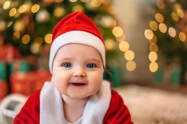 Noel Baba şapkalı bir Noel çocuğu, halıya uzanmış bir çocuk Noel ışıklarının arka planında, Noel konsepti