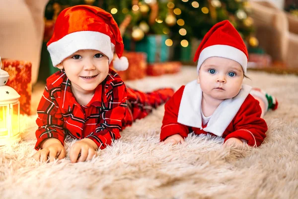 Familia en Nochebuena. Niños bajo el árbol de Navidad con cajas de regalo. Sala de estar decorada con un árbol de Navidad tradicional. Acogedora noche cálida de invierno en casa. — Foto de Stock