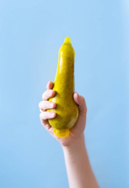 Mavi arka planda kondom ve armut yakın plan..