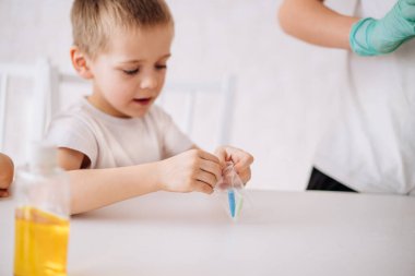 Küçük çocuklar deneyler yapar. Çocuk deney yapmak için bir çanta dolusu toz açıyor. Çocukların erken gelişimi. Araştırma ve geliştirme kavramı.