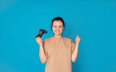 Video oyunu oynayan genç bir esmer, elinde bir kontrolör, kızgın, hayal kırıklığına uğramış ve öfkeli, gözleri kapalı.