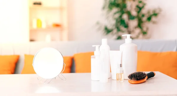 Cosmetic set on a light dressing table. a green bush on the table with cosmetics and a mirror. the concept of home self-care.