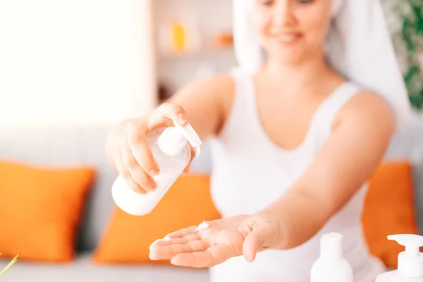 A close-up shot of the hands showing the moisturizer. The beauty holds a jar of skin cream in her hands. A small depth of field with an emphasis on moisturizer