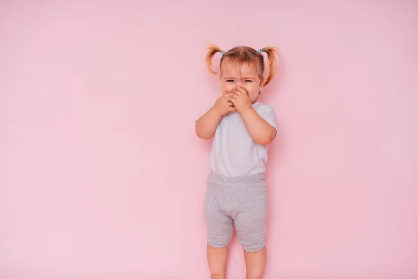照片上一个哭着的两岁小女孩在粉色背景下被隔离 — 图库照片