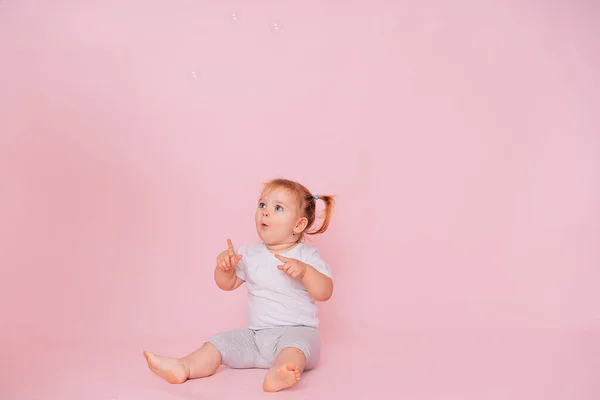 Симпатичная Маленькая Счастливая Девочка Смотрит Указывает Вверх Розовом Фоне Рекламируя — стоковое фото
